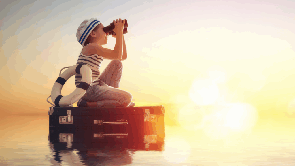 Niño viendo el horizonte con binoculares.